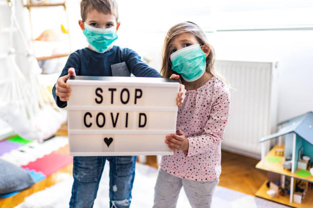 Children wearing pollution masks at home