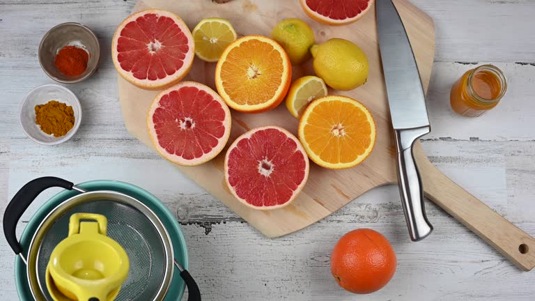 woman squeezing oranges lemons and grapefruits for vitamin C health drink