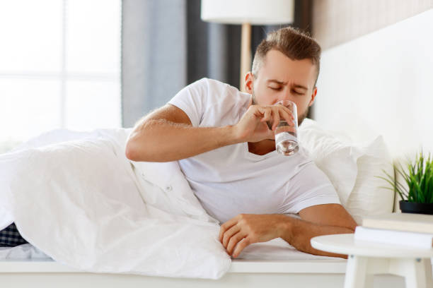 young healthy man drinking water in morning