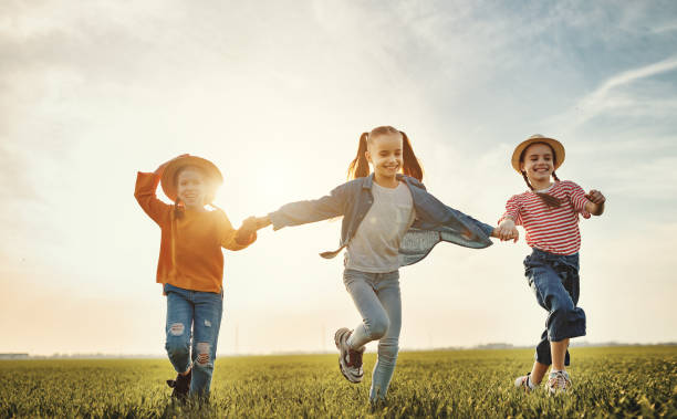 istock Happy children running in field in evening 1212830769