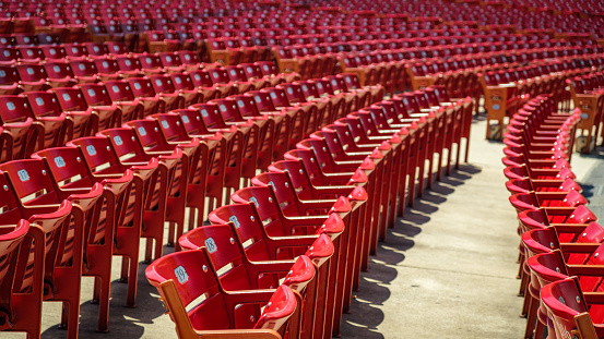 Red stadium chairs in an empty stadium.