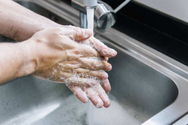 istock two hands of a man washing in a metallic pile 1212840983