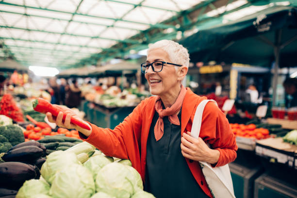 femme aîné faisant des emplettes au marché fermier - supermarket groceries shopping healthy lifestyle photos et images de collection