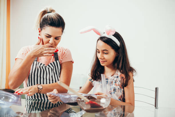 istock Mother and daughter making homemade chocolate easter eggs. Easter in Brazil. 1212846775