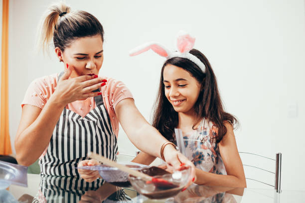 istock Mother and daughter making homemade chocolate easter eggs. Easter in Brazil. 1212846784