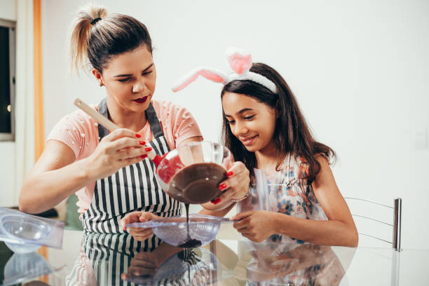istock Mother and daughter making homemade chocolate easter eggs. Easter in Brazil. 1212846788