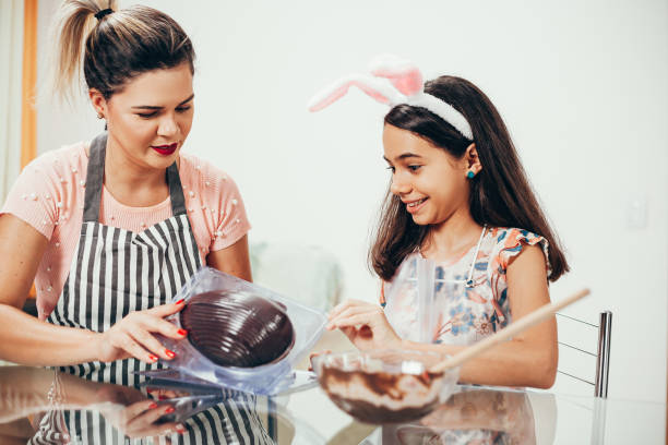 istock Mother and daughter making homemade chocolate easter eggs. Easter in Brazil. 1212846793