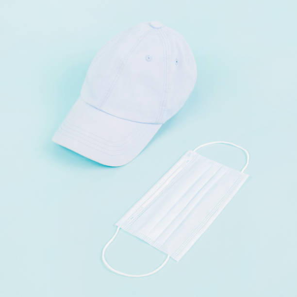 istock Pprotective mask and cap on blue background. Coronavirus protection. Summer style. Quarantine in Europe. Coronavirus 2019. Summer concept. 1212851950