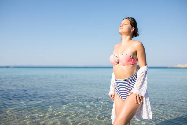 istock Young handsome woman posing on the beach 1212852118