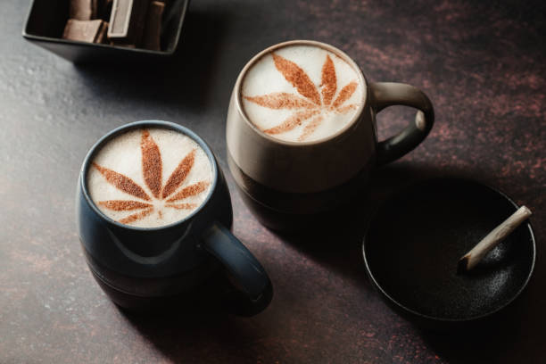 CBD hot beverages, vaping, cannabis joint and cannabis chocolate. Cannabis chocolate leaf on cappuccino foam with vape pen and cannabis joint. Chill out morning vibes, medical or recreational consumption. coffee addict stock pictures, royalty-free photos & images