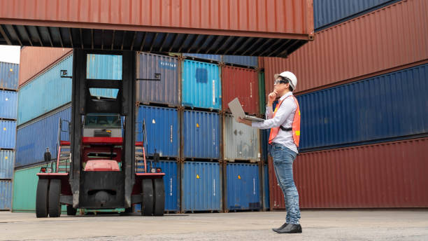 istock asian male containers cargo inspector working and containers yard and cargo with background of containers stack and container forklift 1212859867