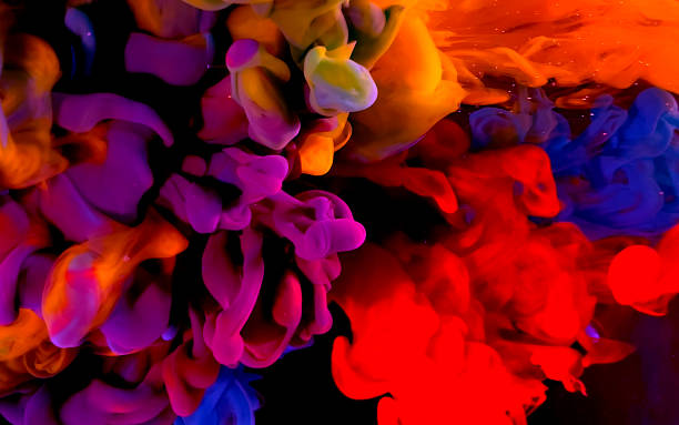 istock Yellow, blue and red watercolor ink in water on a black background. 1212866149