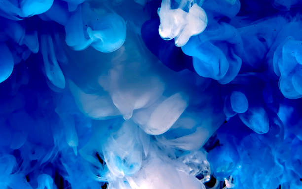 istock Blue and white watercolor ink in water on a black background. 1212866204