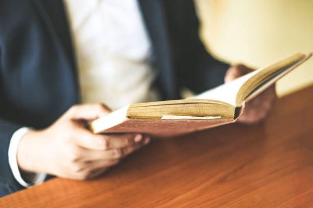 istock Business man or student holding a book on hand - Business education study concept man reading book on the table 1212866369