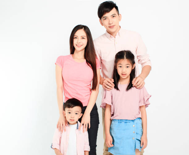 istock happy young asian family standing before white background 1212869408