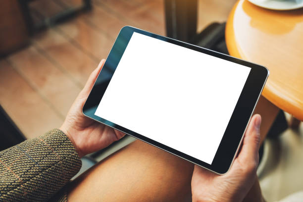 istock a woman sitting and holding black tablet pc with blank white desktop screen 1212869447