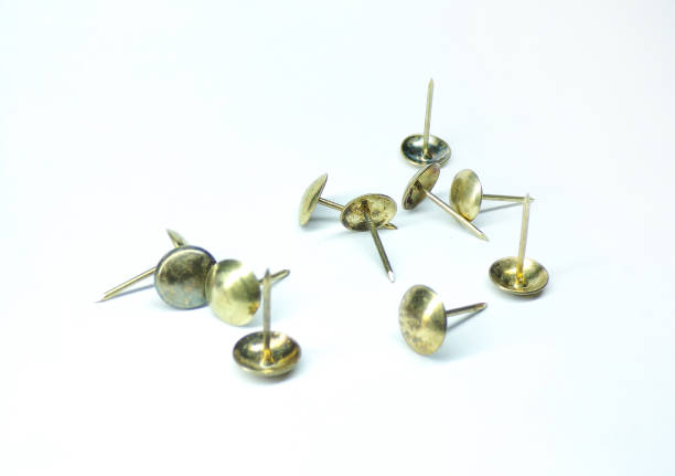 istock Lots of metal studs on a white background. Carnations with a Golden hat. Template. Construction. 1212875710
