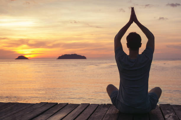 yoga zen y meditación, silueta del hombre sentado en el muelle al atardecer - equanimity fotografías e imágenes de stock