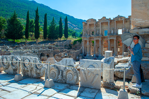 Selcuk-Izmir, Turkey - June 22, 2019: Tourists walking around in UNESCO heritage site Ephesus on sunny day. Celsus Library one of the most beautiful structures in Ephesus