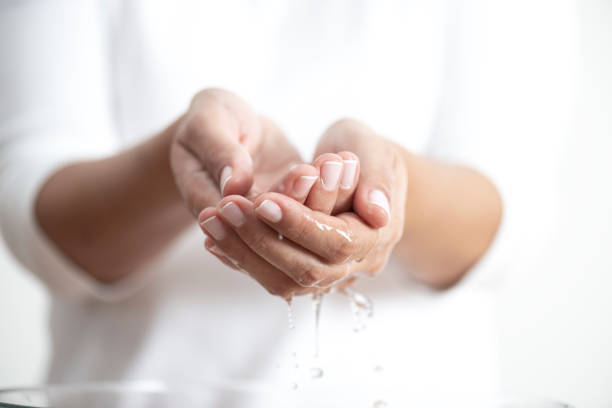 Water Hands of a caucasian female wearing white clothes is trying to hold water in her hands. condensation photos stock pictures, royalty-free photos & images