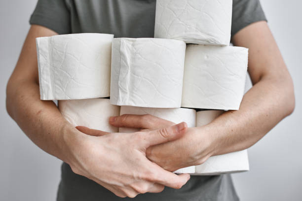 People are stocking up toilet paper for home quarantine from crownavirus People are stocking up toilet paper for home quarantine from crownavirus. Woman holds many rolls of toilet paper sold out photos stock pictures, royalty-free photos & images