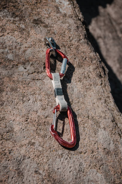 istock Red carabiner express hook hanging on the rocky background 1212886727
