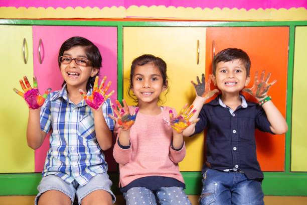 istock Kids playing with colour paint in preschool,day care activity 1212894823