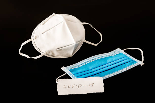 istock Disposable medical mask in black background 1212895886