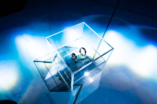 istock two wedding rings in square glass box in dark 1212898797