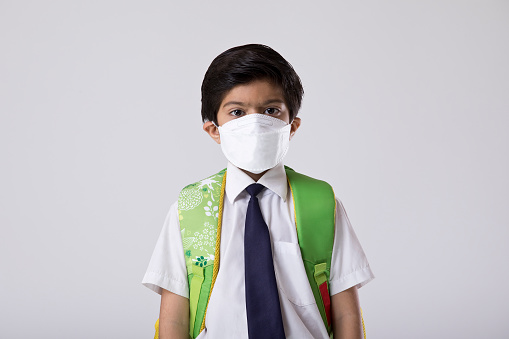 Schoolboy wearing protective face mask to prevent from virus infectious disease