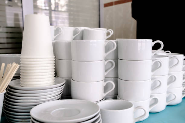 Exposed on stacks of white clean ceramic cups and saucers. Dishes in the restaurant for tea and coffee. Exposed on stacks of white clean ceramic cups and saucers. The dishes in the restaurant are prepared for tea drinking and coffee drinking. tea party horizontal nobody indoors stock pictures, royalty-free photos & images