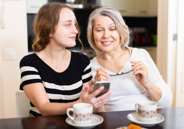 istock Mother with daughter using smartphone 1212903587