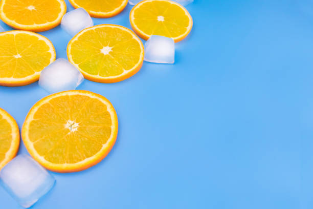 istock Orange slices and ice  on a blue background. Copy space. 1212913892