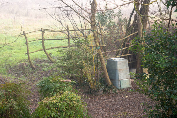 Plastic compost bin in a backyard of a farmhouse on a misty winter morning