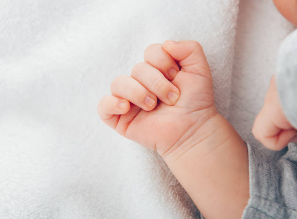 istock Newborn baby's hand close-up on white blanket 1212917796