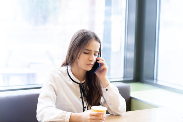 Young girl talking on a smartphone in a cafe
