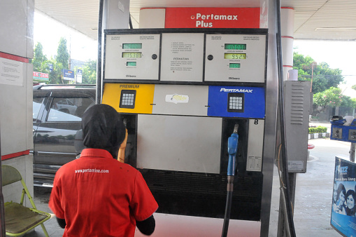 Jakarta, Indonesia - September 9th, 2014: Muslim workers wear the hijab while refueling for vehicles in Jakarta, Indonesia