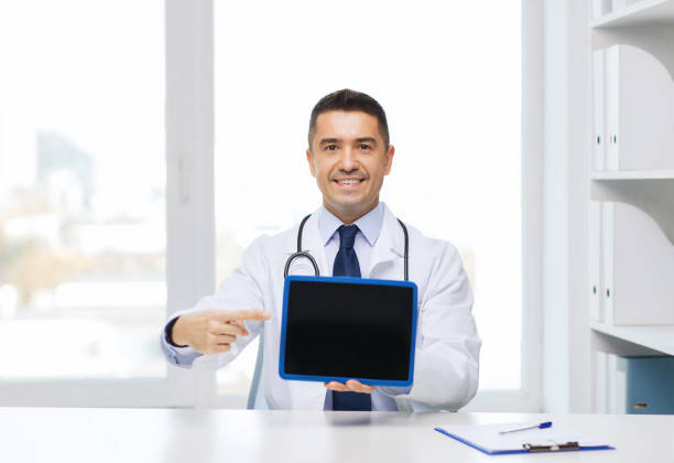 istock smiling male doctor showing tablet pc blank screen 1212921203