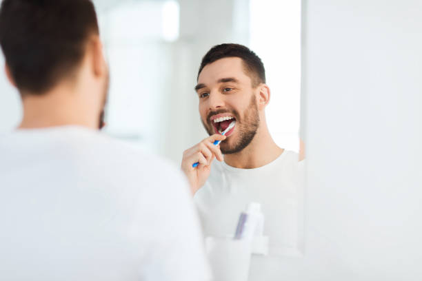 istock man with toothbrush cleaning teeth at bathroom 1212922756