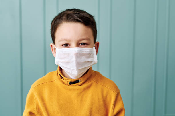 istock 6-7 years old cute child wearing surgical mask. 1212923742