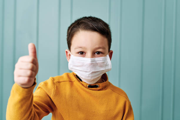 istock 6-7 years old cute child wearing surgical mask. 1212923913