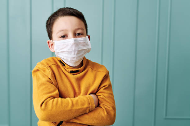 istock 6-7 years old cute child wearing surgical mask. 1212924087
