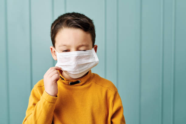 istock 6-7 years old cute child wearing surgical mask. 1212924219