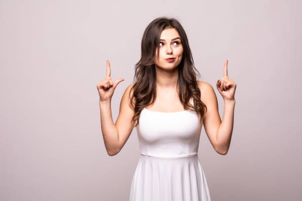 istock Funny young woman pointing finger up isolated over grey background. 1212924290