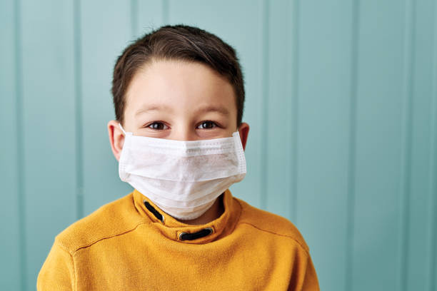 istock 6-7 years old cute child wearing surgical mask. 1212924569
