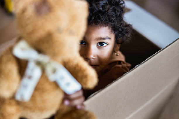 istock Cute black girl in a cardboard box. 1212925248