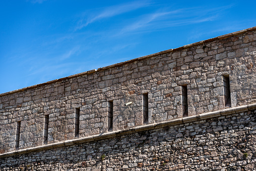 Trento, Trentino Alto Adige, Italy - March 8th, 2020: Castello del Buonconsiglio or Castelvecchio Medieval castle (XIII-XVIII century) in Trento city. Closeup of the fortified wall with the arrow slits or loopholes. Trentino Alto Adige, Italy, Europe