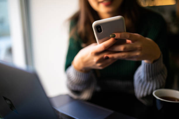 istock Young woman reading sms on the phone in cafe 1212926834