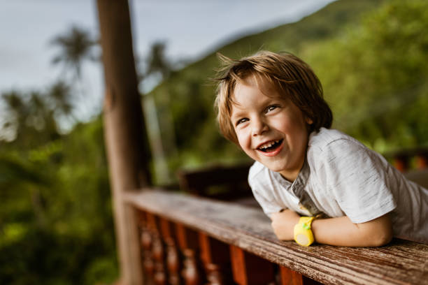 Cute little boy relaxing on a balcony and looking away.
