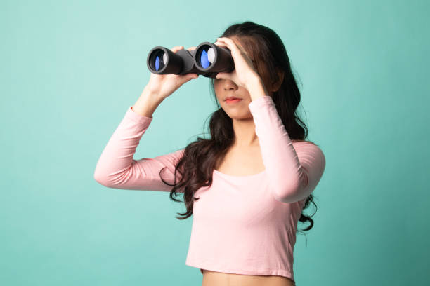istock Young Asian woman with binoculars. 1212928349